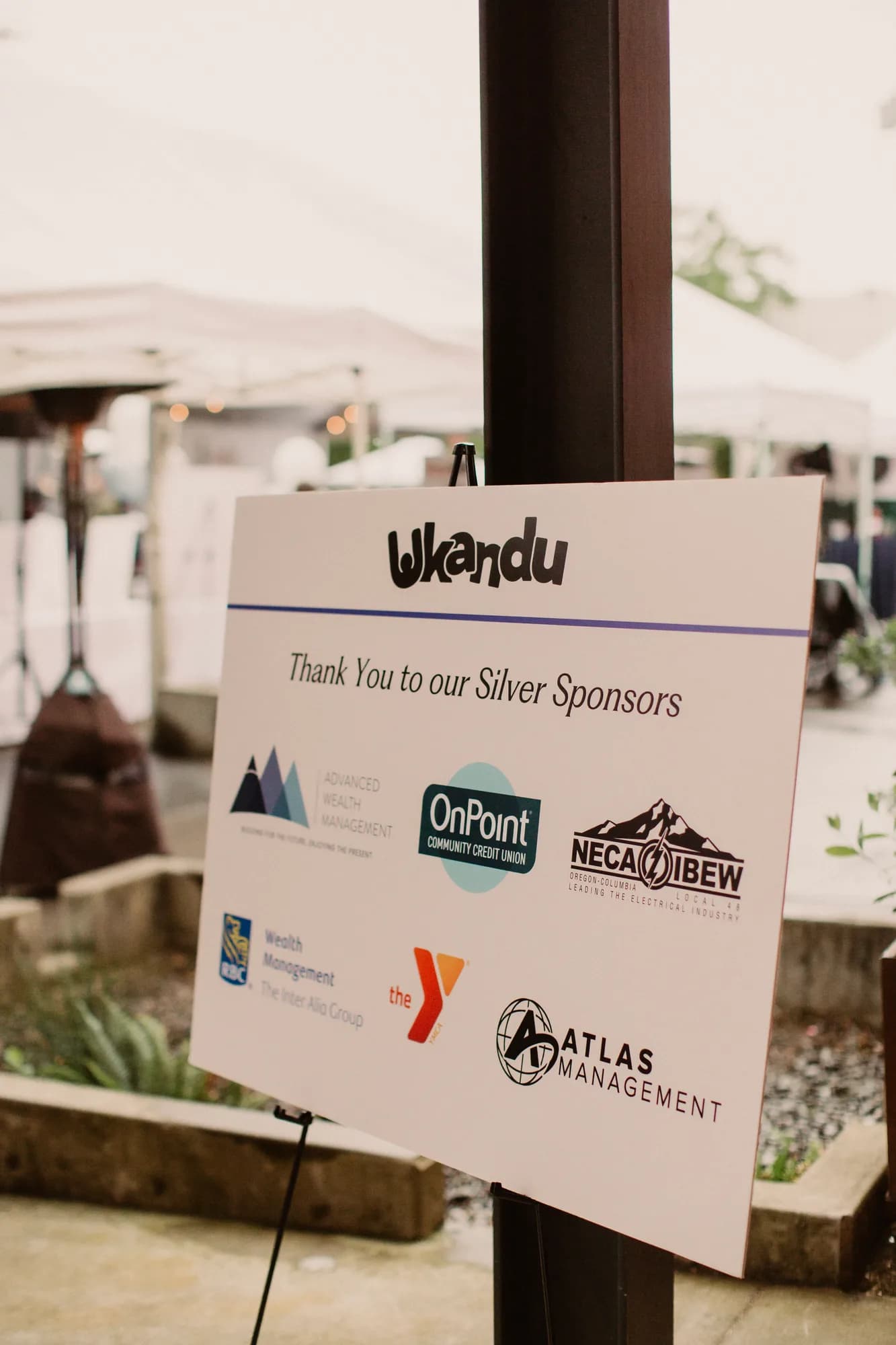 Ein Schild, das Ukandus Silber-Sponsoren beim Wine & Dine for Hope & Joy dankt