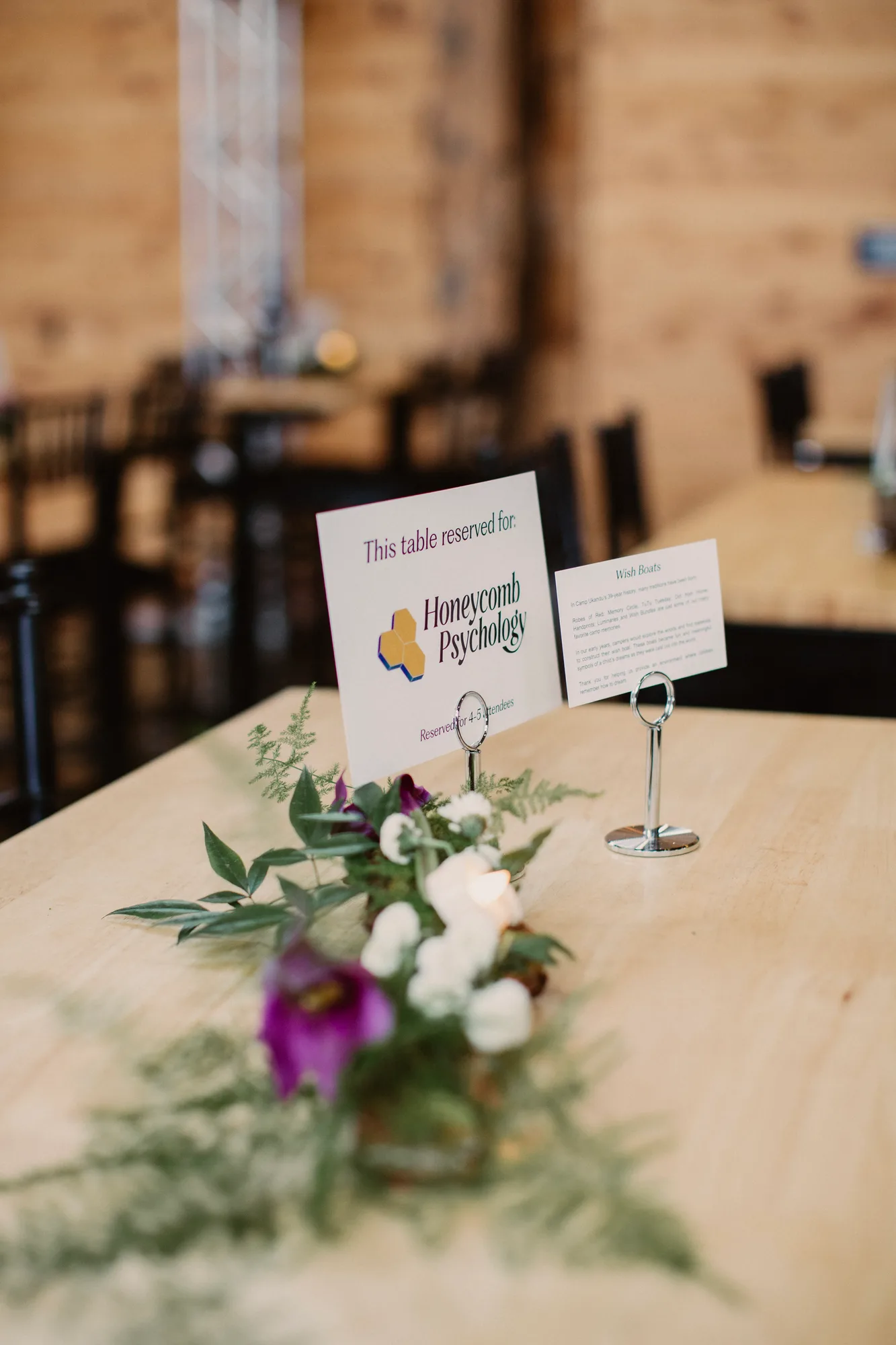 Tischkarte und Gesteck eines Sponsors in der Scheune beim Wine & Dine for Hope & Joy