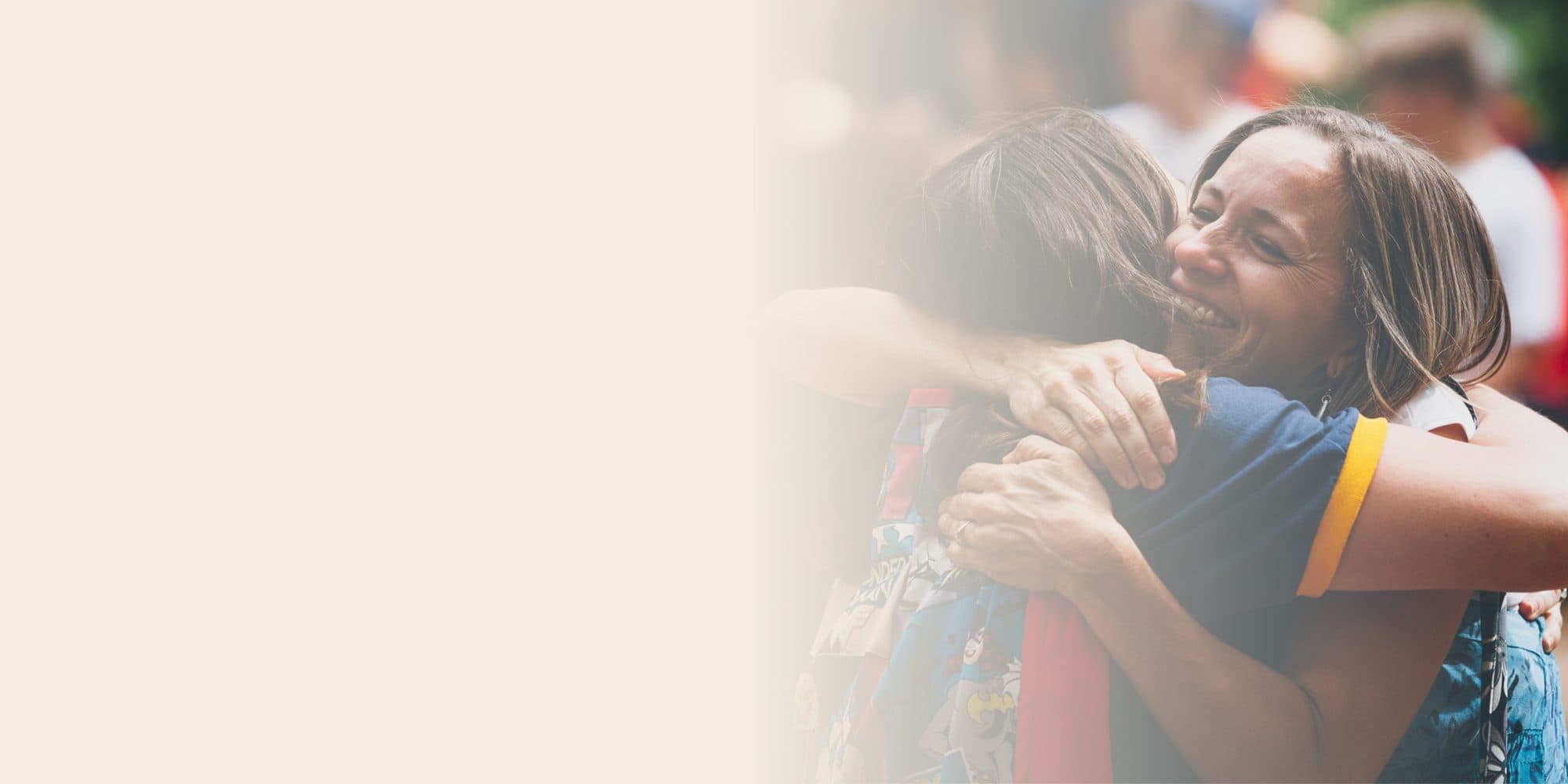Photo of two people sharing a hug with cream gradient overlay