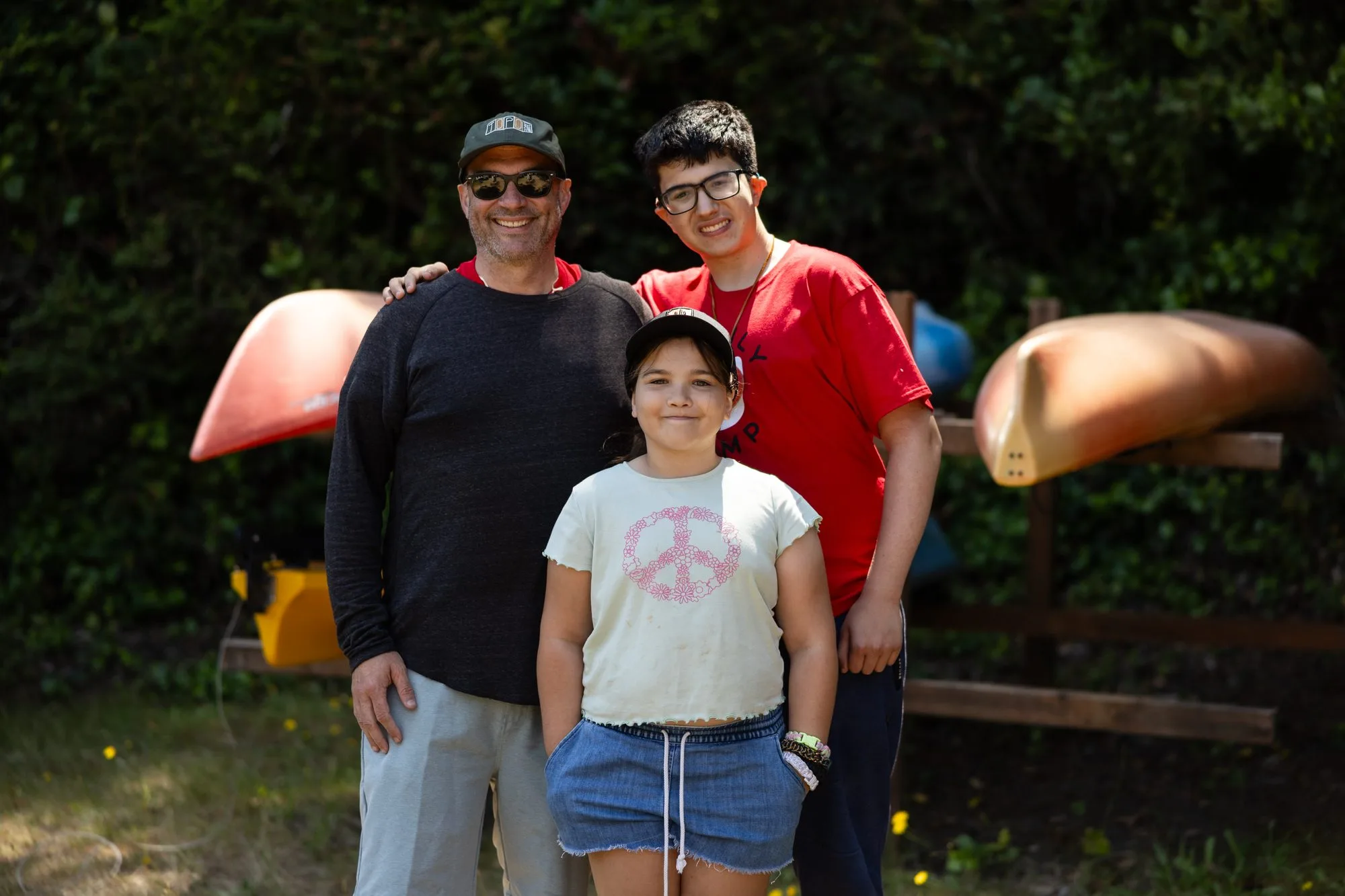 A family with a dad and two children smile for a photo together