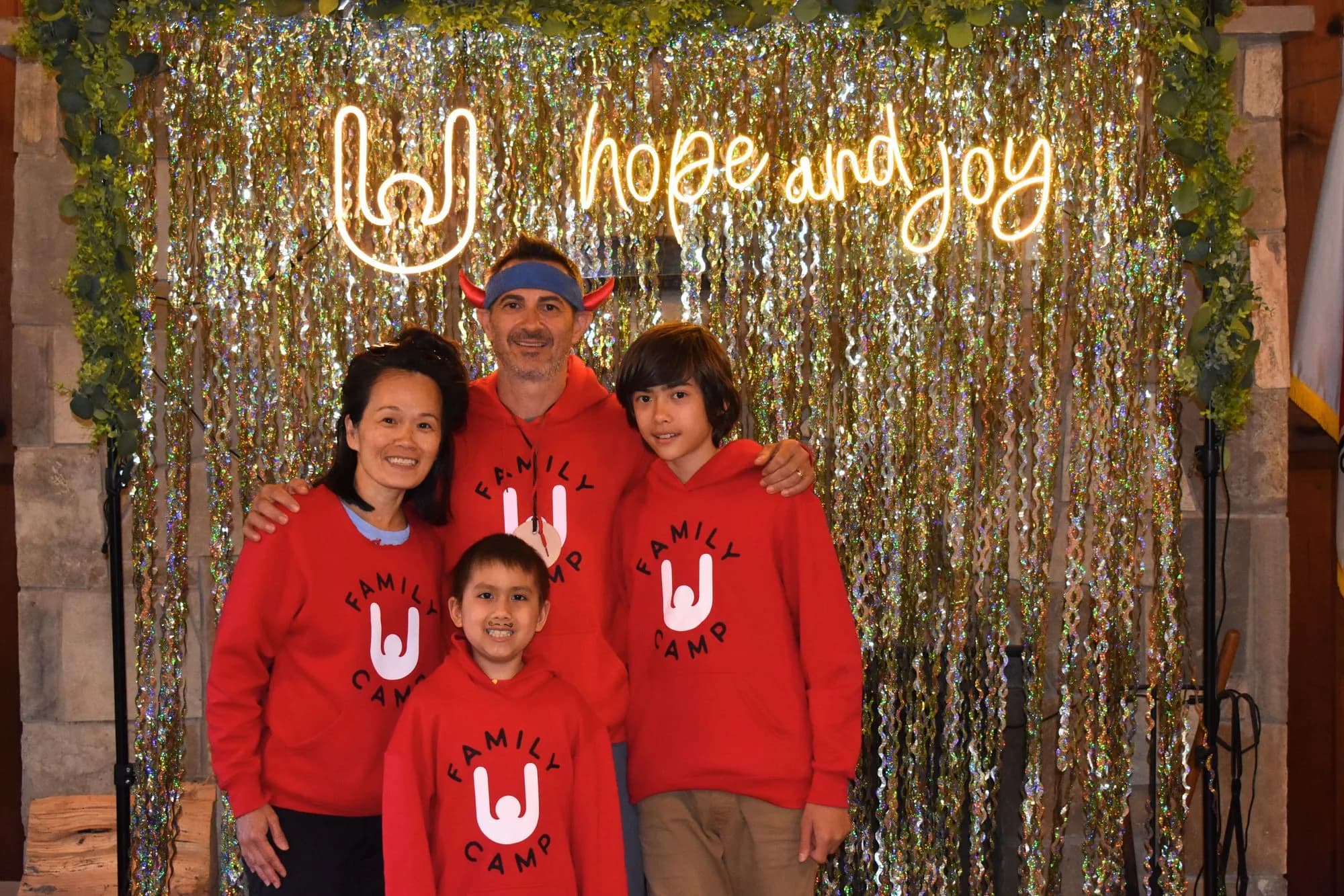 Family photo in front of hope and joy sign