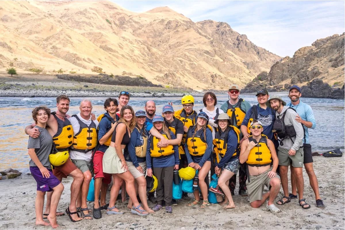 Group photo of teen retreat participants in yellow life jackets